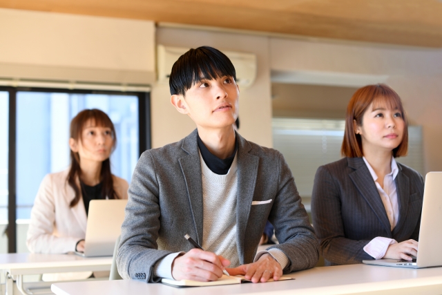 講演者がスクリーン前でプレゼンを行うセミナーの様子